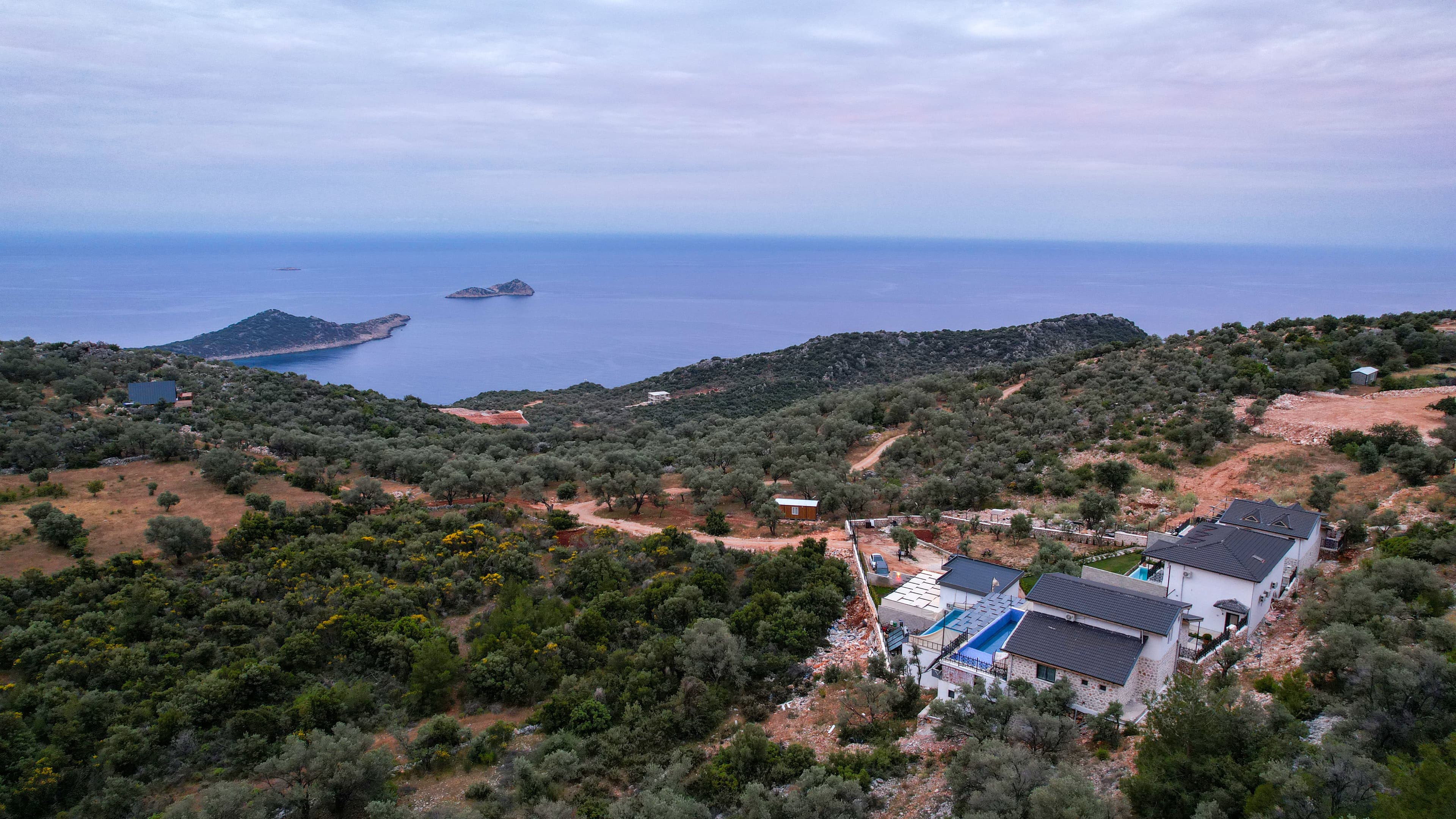 Aerial view of the five villas together on the hillside above Kalkan, each with its own pool and sea view